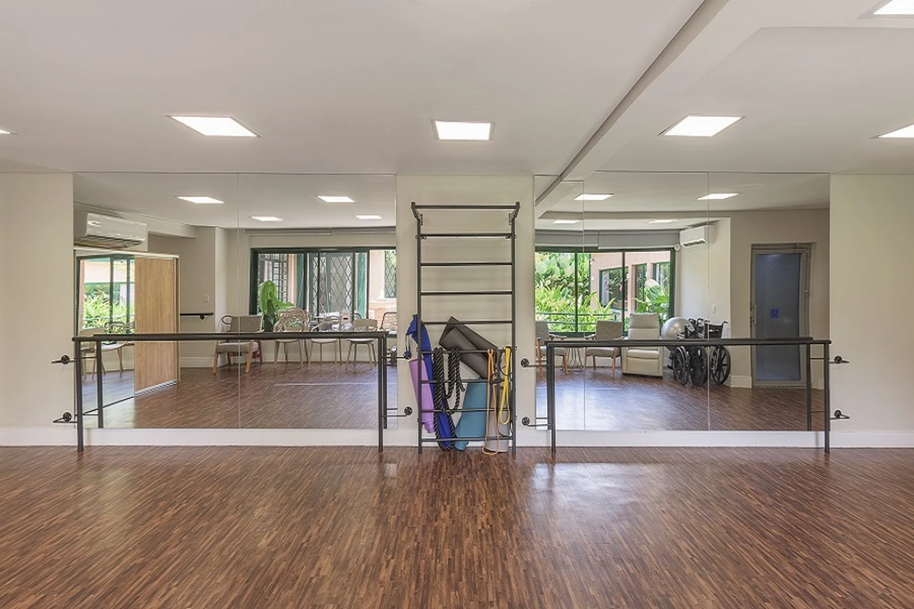 Espaço de fisioterapia e exercícios para idosos, com equipamentos específicos para reabilitação e fortalecimento muscular.